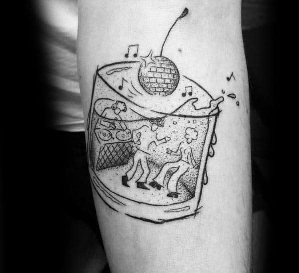 Creative blackwork tattoo of a whiskey glass filled with dancing figures, a disco ball cherry, and music notes, blending party and cocktail themes.