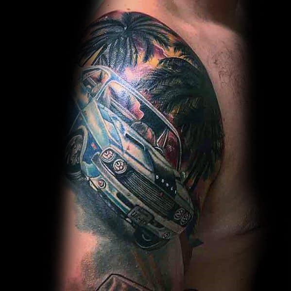 Vibrant Dodge muscle car tattoo on shoulder, featuring palm trees and a sunset, creating a bold and dynamic tropical-themed design.
