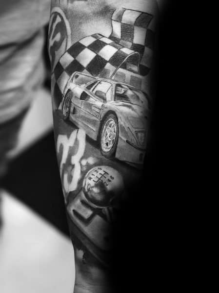 Detailed black-and-grey Ferrari F40 tattoo with racing flags and gear shift on man's arm, symbolizing speed, precision, and racing heritage.