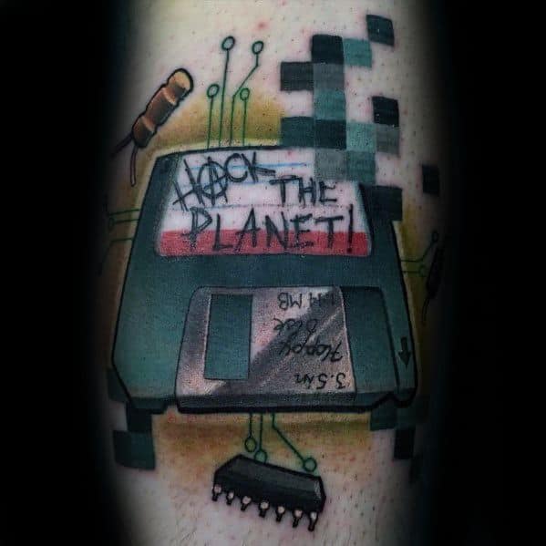 Colorful tattoo of a 3.5" floppy disk with pixelated effects and the phrase "Hack the Planet!" scribbled on the label.