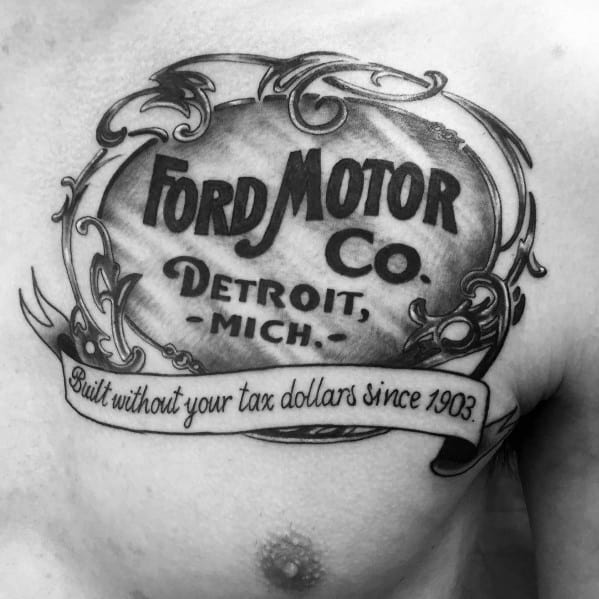 Vintage Ford Motor Co. tattoo on chest, featuring ornate detailing, bold lettering, and the phrase "Built without your tax dollars since 1903."