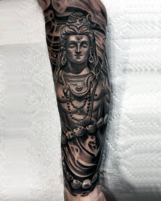 Realistic full-arm tattoo of Lord Shiva with detailed ornaments, a crescent moon, and a snake around his neck, exuding divine calm and strength.