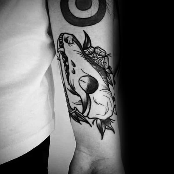Blackwork tattoo of a fox skull with bold outlines and floral accents, placed on the outer forearm for a clean, striking look.
