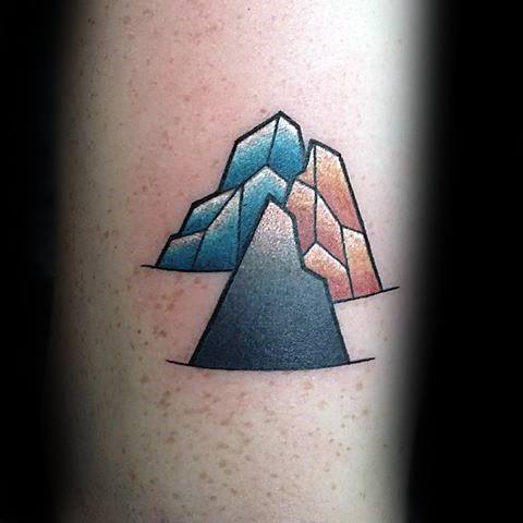 Colorful geometric mountain tattoo with bold black peak in front and shaded blue-orange tones on the back peaks.