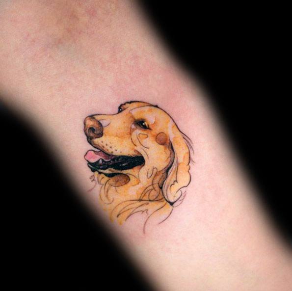 Small watercolor-style Golden Retriever tattoo on the forearm, featuring warm tones, soft shading, and delicate linework for a playful look.