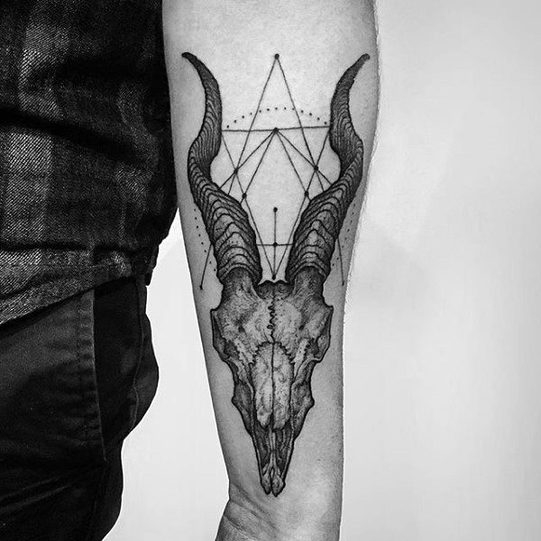 Black and grey forearm tattoo featuring a detailed ram skull with large curved horns, accented by geometric lines for a gothic and mystical aesthetic.