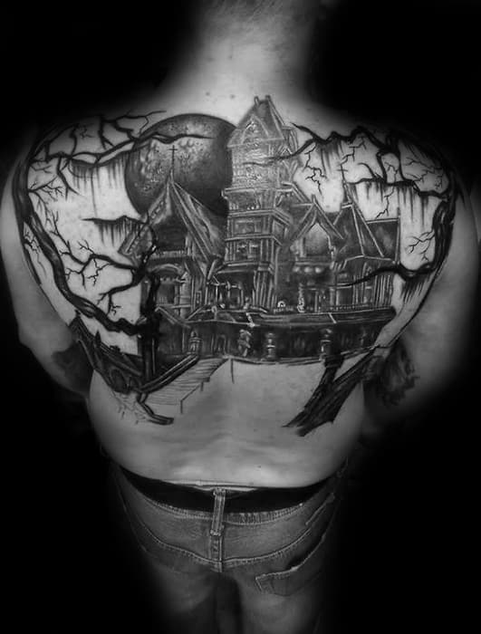 Full back tattoo of a haunted mansion with intricate gothic details, full moon, bare trees, and eerie shadows creating a chilling night scene.
