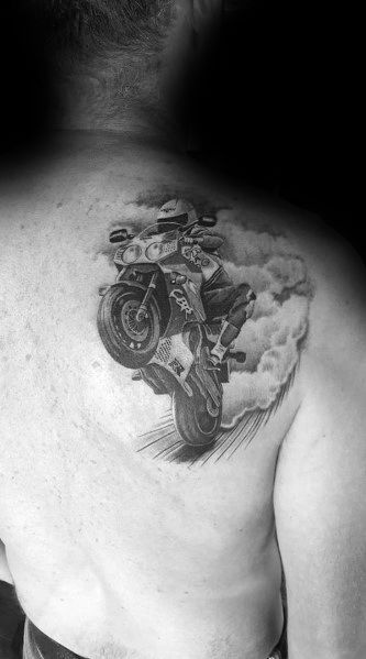 Realistic Honda sportbike tattoo on a man's back, featuring a rider performing a wheelie with detailed shading and smoke effects.