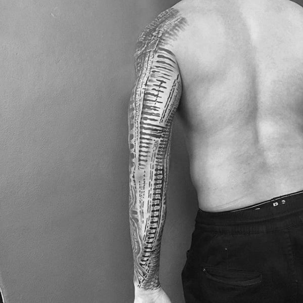 HR Giger-inspired full-sleeve tattoo with abstract biomechanical patterns resembling vertebrae, wires, and alien spinal textures.