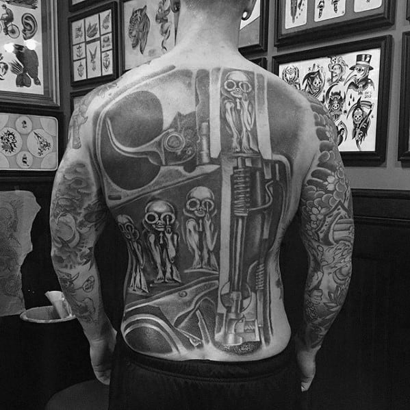 Full-back HR Giger-style tattoo with small alien-like figures embedded in a surreal biomechanical structure resembling a mechanical chamber.
