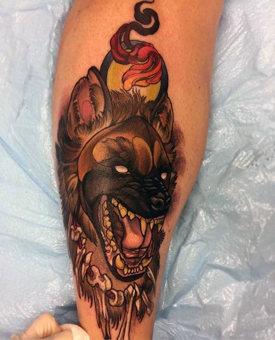 Fierce neo-traditional hyena tattoo with glowing white eyes, sharp teeth, a flaming candle on its head, and a bone necklace for a dark tribal vibe.