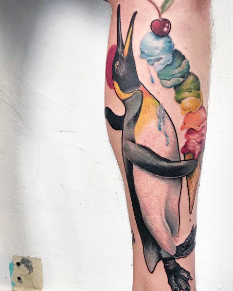 Tattoo of a realistic penguin holding a colorful melting ice cream cone topped with a cherry, blending nature and whimsy in a creative design.