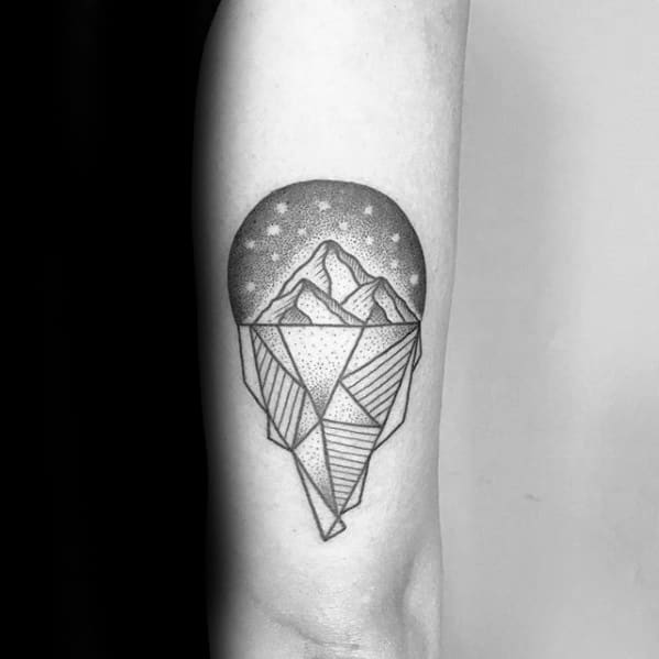 Geometric iceberg tattoo with dotwork shading and a starry sky above, blending structured lines with soft cosmic detail.