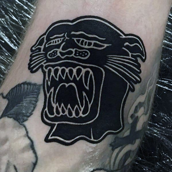 Bold black panther tattoo with a stylized face and wide-open mouth, outlined in white for a striking inverted effect.