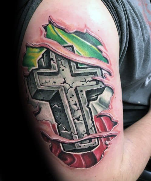 Upper arm tattoo with a torn skin effect revealing a stone cross over the Italian flag, symbolizing faith, strength, and deep cultural pride.