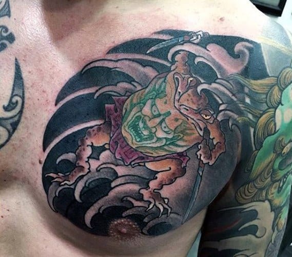 Japanese-style chest tattoo featuring a fierce warrior toad wearing a menacing mask, gripping a weapon, surrounded by swirling black waves for a bold look.