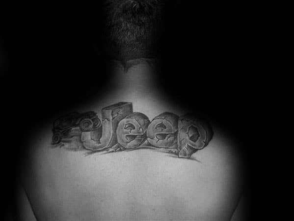 Black and grey tattoo of the word "Jeep" in a rugged, stone-like 3D design, placed across the upper back for a bold off-road look.