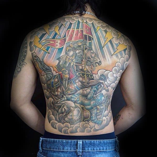 Epic full-back tattoo of Joan of Arc charging into battle on horseback, with storm clouds, lightning, and dramatic medieval armor and flags.