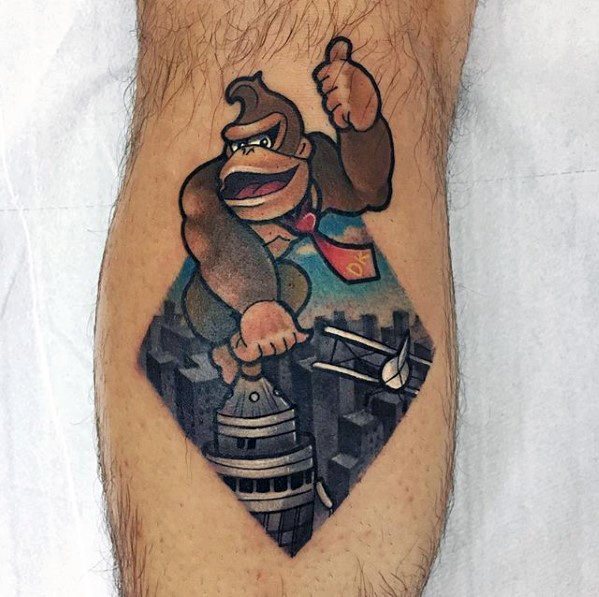 Cartoon-style Donkey Kong tattoo parodying King Kong, showing him atop a skyscraper with planes flying around a city backdrop.