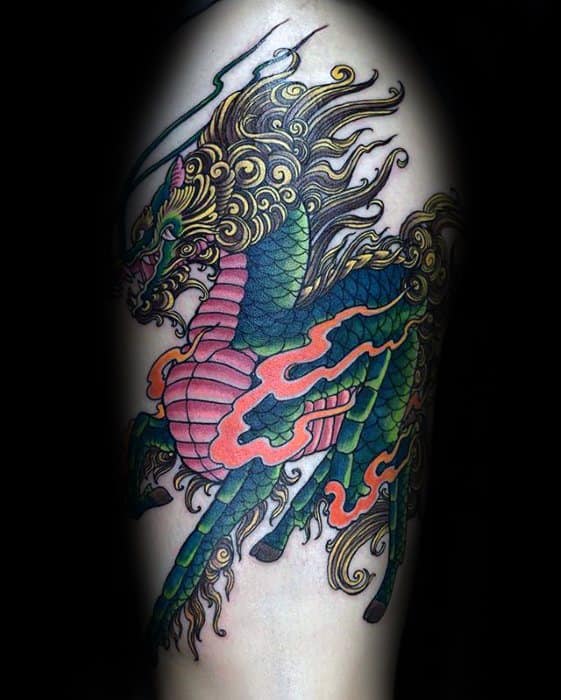 Vibrant Kirin tattoo with green scales, golden mane, red flames, and a fierce gaze, captured mid-leap in traditional Japanese style.