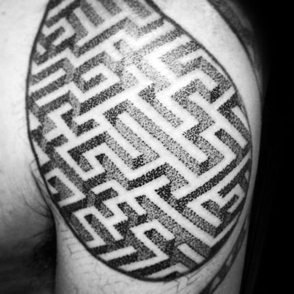 Blackwork labyrinth tattoo on a man's shoulder, featuring an intricate maze pattern with dotwork shading, creating depth and texture.