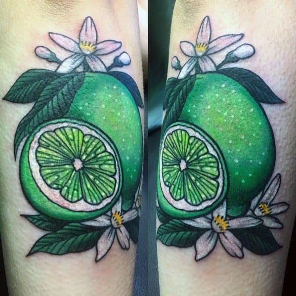 Vibrant lime tattoo with bold green shading, detailed leaves, and white citrus blossoms, creating a fresh and lively botanical design.