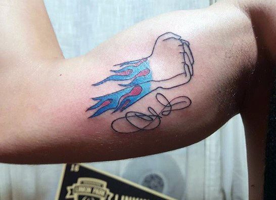 Minimalist tattoo of Chester Bennington’s iconic flame wrist design with a clenched fist outline and his signature on the bicep.