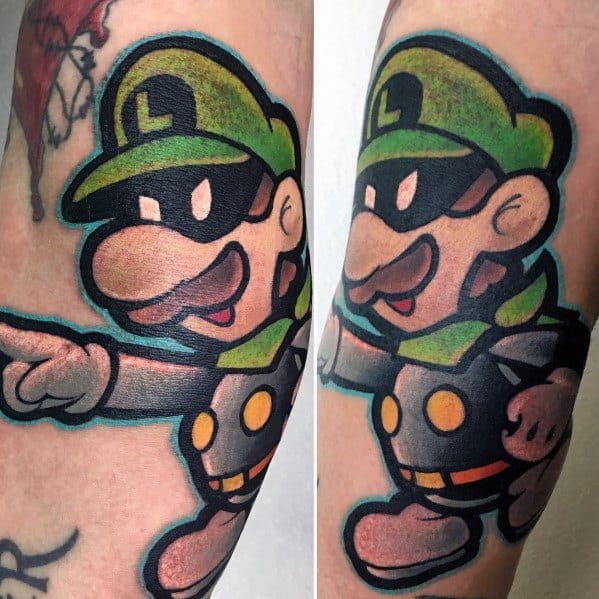 Bold tattoo of Luigi in his Mr. L persona, featuring a masked face, dark outfit, and a confident pose, outlined with thick black lines.