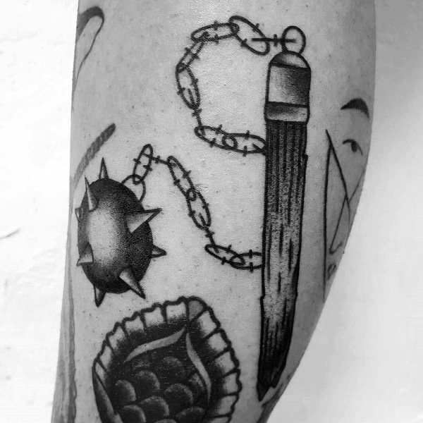 Black and gray mace tattoo featuring a spiked ball on a barbed chain connected to a wooden handle, symbolizing strength, battle, and resilience.