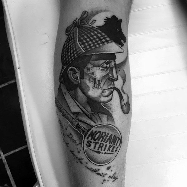 Tattoo of Sherlock Holmes with a magnifying glass reading "Moriarty Strikes," featuring bold shading and classic detective-themed elements.