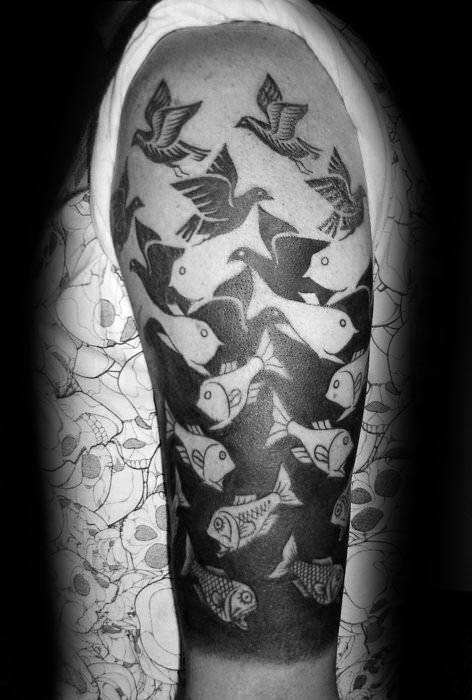 MC Escher-inspired upper arm tattoo with birds seamlessly transforming into fish in a bold, black-and-white tessellation pattern.
