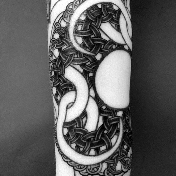 MC Escher-inspired tattoo featuring intricate interwoven knots and swirling patterns creating an optical illusion around a central blank circle.