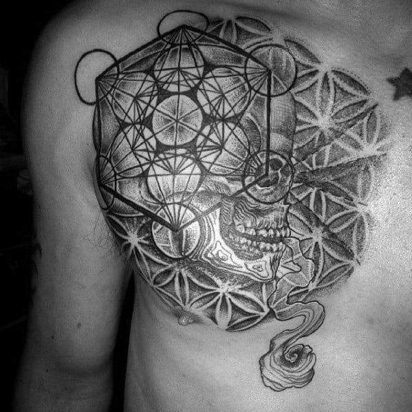Chest tattoo combining Metatron’s Cube, a half-skull, and Flower of Life patterns with detailed shading and smoke-like flow beneath.