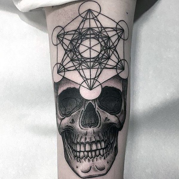 Black ink Metatron’s Cube tattoo above a realistic skull, blending sacred geometry with dark, detailed anatomical art.
