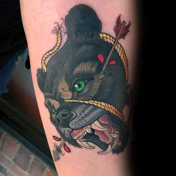 Neo-traditional bear tattoo featuring a fierce roaring bear with vivid green eyes, a rope wrapped around its face, and an arrow piercing through.