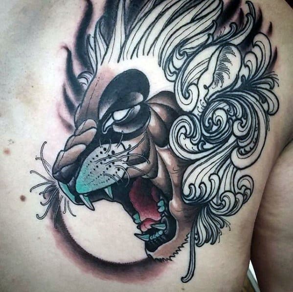 Abstract neo-traditional lion chest tattoo with flowing mane, stylized shading, and turquoise highlights for a surreal, fierce look.
