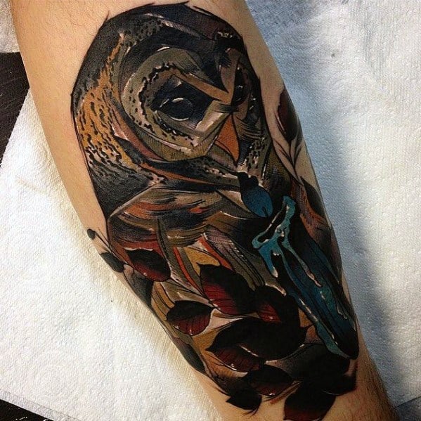 Neo-traditional owl tattoo with dark earthy tones, bold shading, and a mysterious dagger detail, creating a moody and intricate design.