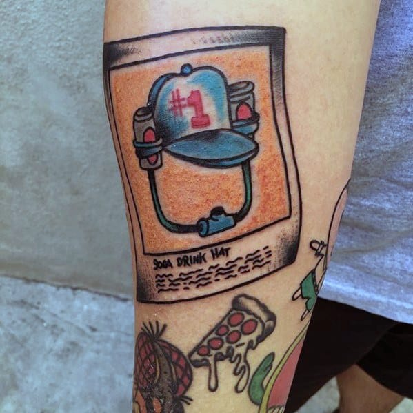Tattoo of the iconic "#1 Soda Drink Hat" from SpongeBob, framed like a Polaroid photo with playful shading and nostalgic detail.