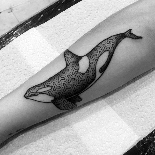 Black and white orca tattoo on the forearm, featuring bold, abstract patterns filling the whale's body for a contemporary design.