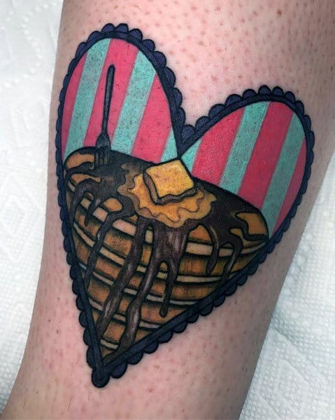 Heart-shaped pancake tattoo with chocolate syrup, butter, and a vintage striped background, outlined in bold black for a retro-inspired design.