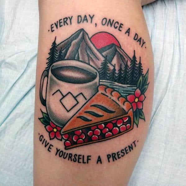 Cherry pie and coffee tattoo with a mountain backdrop, floral details, and the quote “Every day, once a day, give yourself a present”