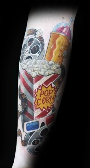 Tattoo of a movie-themed design with popcorn, soda, film reels, and 3D glasses in a vibrant, cinematic style.