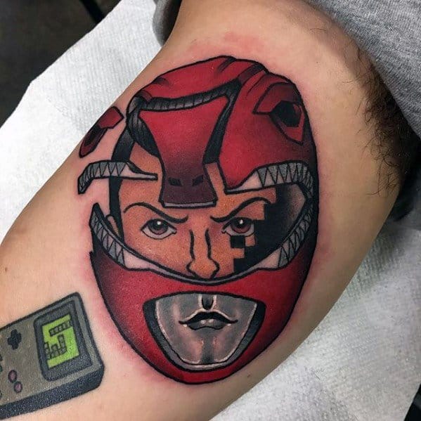 Creative Red Ranger helmet tattoo revealing a stylized face inside, with bold black lines, red tones, and a retro twist.