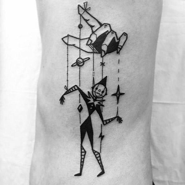 Playful geometric puppet tattoo of a jester marionette controlled by a stylized hand, with planets and stars hanging alongside the strings.