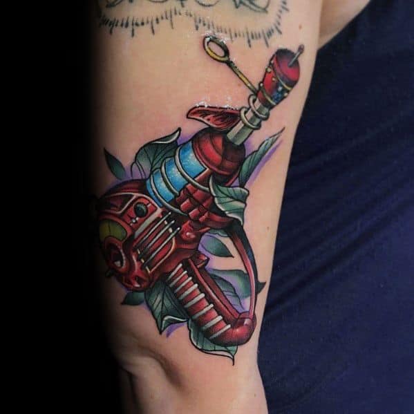 Vibrant neo-traditional ray gun tattoo with bold red and blue tones, intricate shading, and leaves entwined around the futuristic weapon.