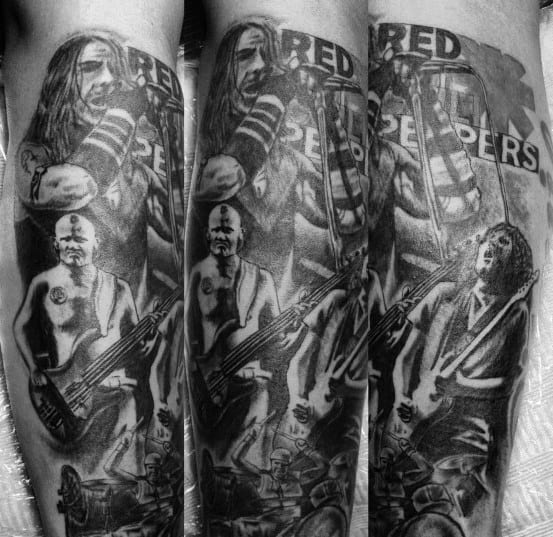 Full sleeve tattoo featuring realistic black and grey portraits of Red Hot Chili Peppers band members in a dynamic live performance scene.