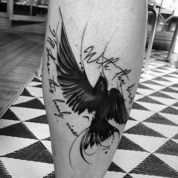 Leg tattoo featuring a bold black ink bird in flight, combined with flowing handwritten lyrics for an artistic and expressive design.
