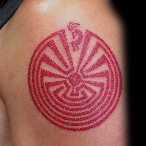 Red Kokopelli tattoo combined with a circular maze pattern, symbolizing a journey or spiritual path.