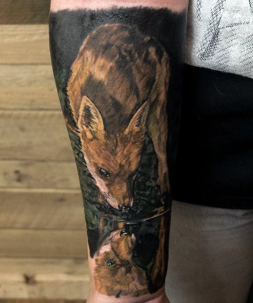 Tattoo of a fox drinking water, with its reflection showing a detailed and lifelike mirror image, creating a stunning nature-inspired design.