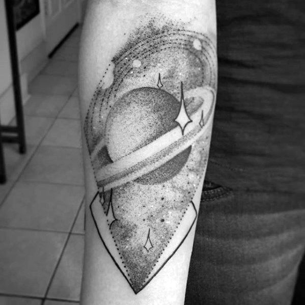 Dotwork Saturn tattoo design for men with sparkles and orbits inside a pointed geometric frame, blending realism and abstract style.